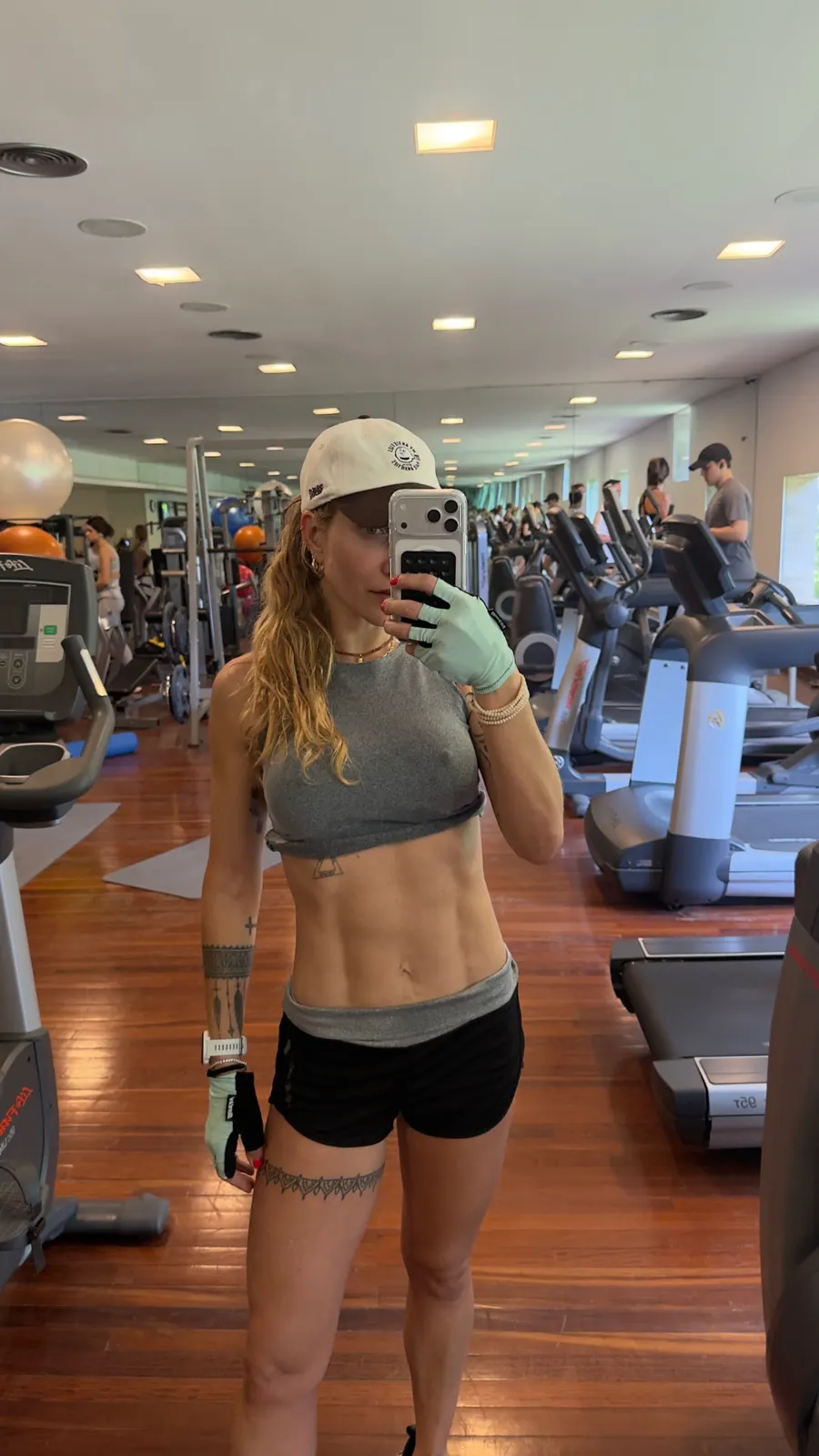 Gabriela Morais em treino na academia, de boné e roupa esportiva.